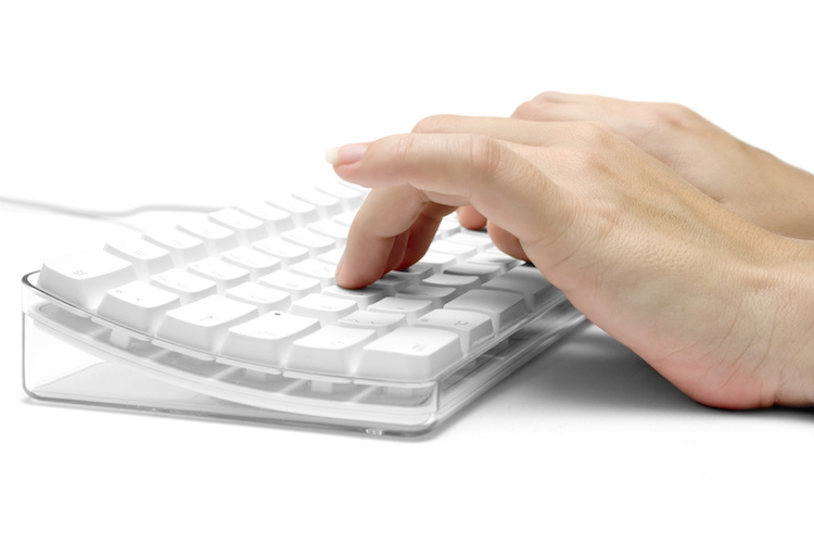 Female hands typing on a white computer keyboard. White background.